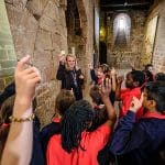 school group on a guided tour with guide at a abbey