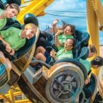 school group including a teacher enjoying a fast moving theme park ride