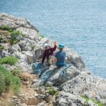 students overlooking a cliff at the seaside looking out to sea