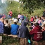 school group around a camp fire