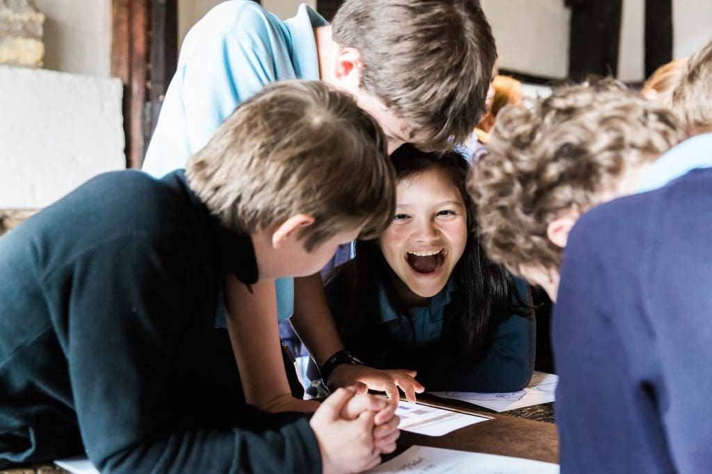 a group of school students looking at museum artifacts and information