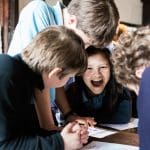 a group of school students looking at museum artifacts and information