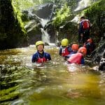 group of school trip pupils gorge walking in up the mountains