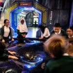 four students on an interactive puzzle machine at a science centre