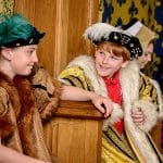 two pupils dressed as a Tudor king and queen sat on thrones