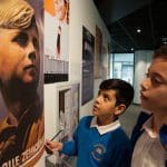 school pupils looking at artifacts in museum room