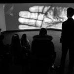 school pupils watching large projector screen in room