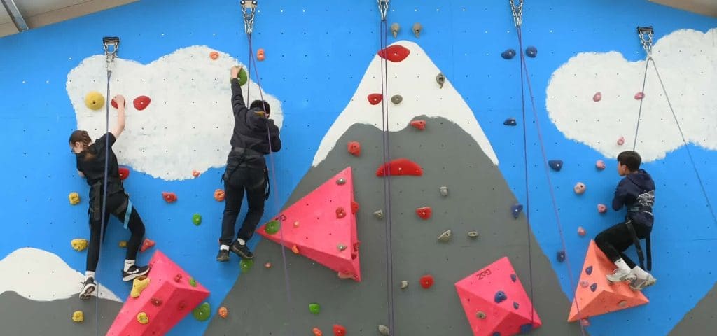 Llain Residential Activity Centre Llanarth Wales 2 school group climbing up an outdoor climbing wall