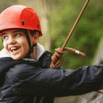 student with hard hat and climbing ropes