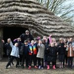 students waving outside a Celtic age building