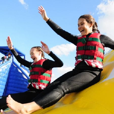 two school pupils sliding down an object