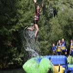 girl flying in the air on an water inflatable object