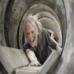 school pupil crawling through a hole