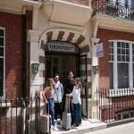 front of hostel building with entrance and group of students standing by entrance