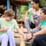 school group make a raft from rope, bamboo sticks and blue plastic drums