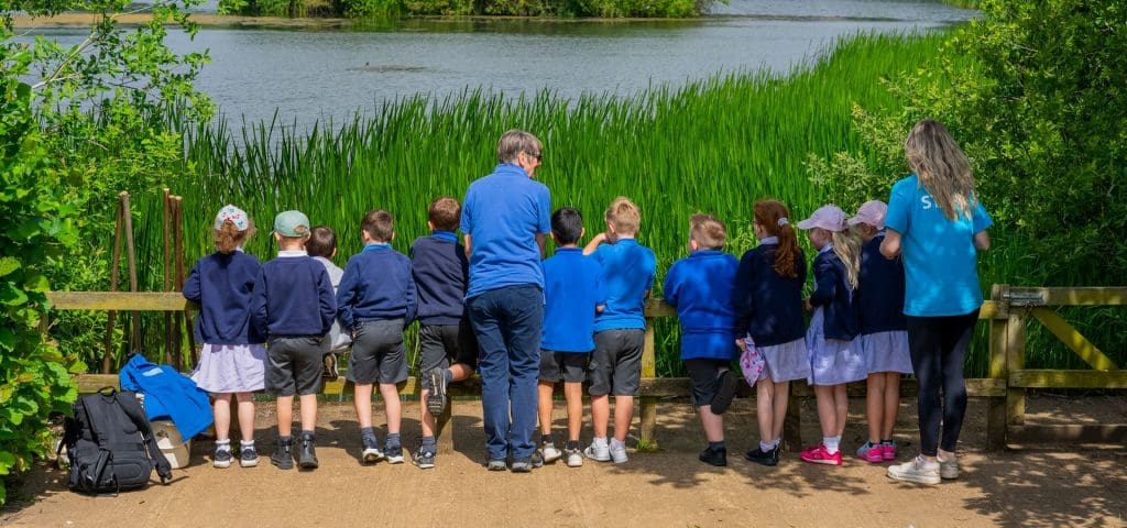 primary school trip group at nature centre looking at wildlife