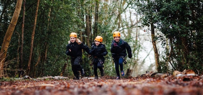 school pupils running along a forest track