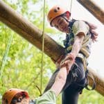 student abseiling down from tower