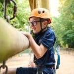 school pupil on a school trip climbing up a ladder