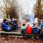 primary school group sitting around a camp fire