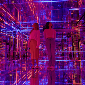 students in a glass room with various bright images and lights