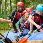 pupils on an activity trip in a boat on a river