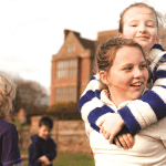 school pupils hugging each other outside an accommodation block