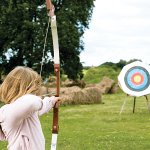 school student doing archery outside