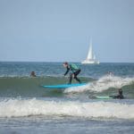 group of pupils surfing at the beach
