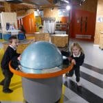 school pupils in a science exhibition room playing with immersive objects