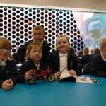 school group on a STEM trip building a machine