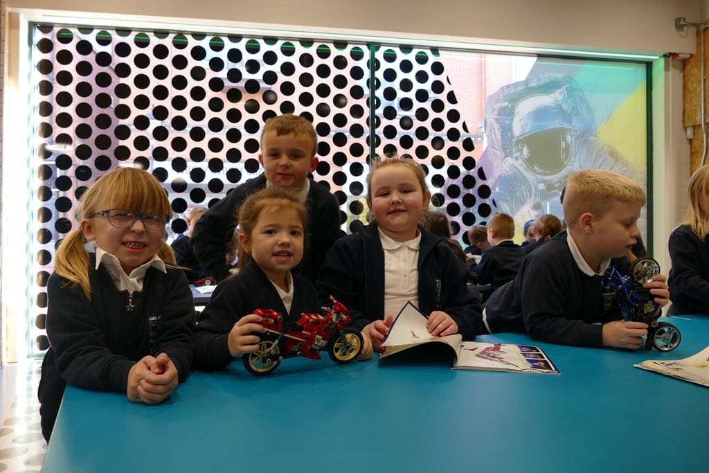 school group on a STEM trip building a machine