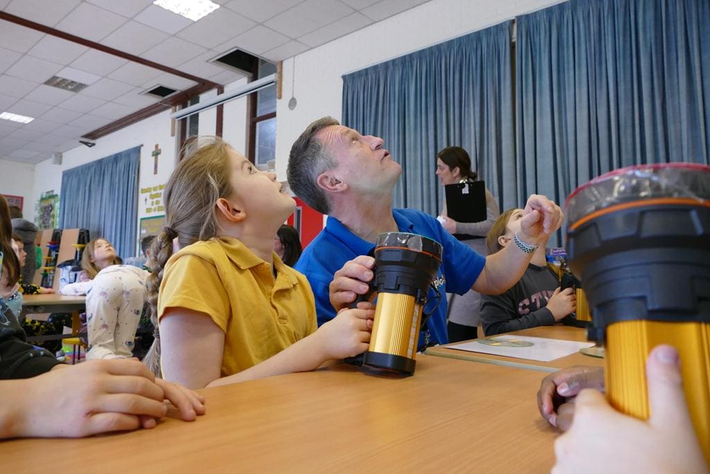 pupils and Xplore science tour guide making lights on a ceiling for a science task