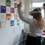 secondary school pupil with 4D immersive face masks and hand control sticks in classroom