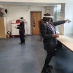 two school pupils with 4D immersive face masks and hand control sticks