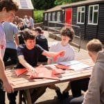 group of school trip students outside completing puzzles and tasks