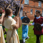 school trip pupils outside dressed in Saxon Clothing playing