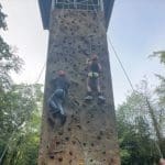 pupils climbing a climbing tower outside