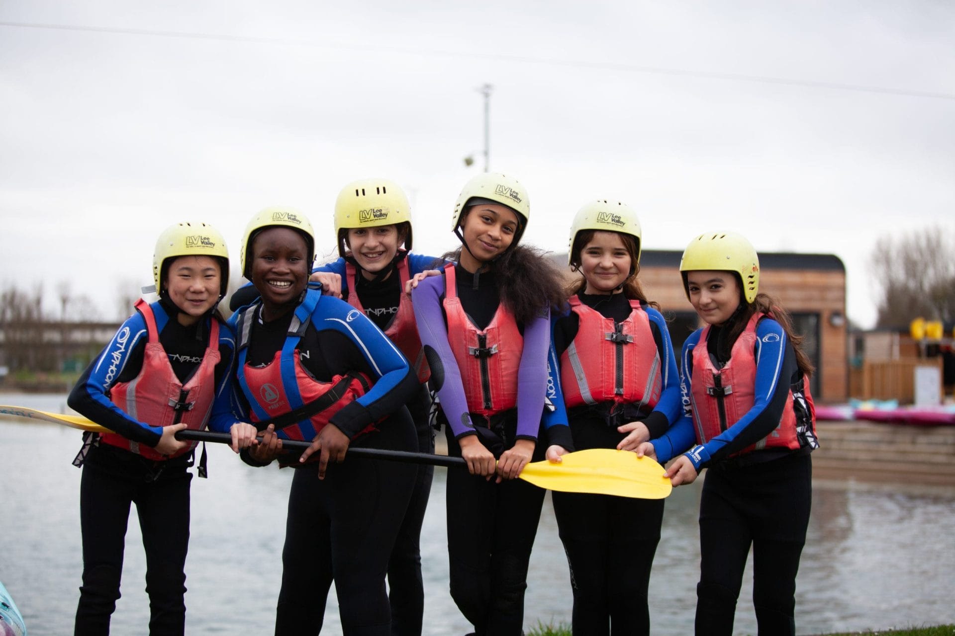 group of school pupils with hard hats and life jackets having a group photo at Land and Wave Dorset