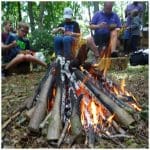 Horstead Activity Centre image of group around an open fire in the woods