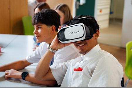 secondar school pupil with a VR headset on in a classroom