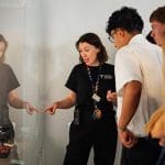 students from college on an educational tour with an instructor talking about artifacts