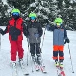 three school pupils skiing down a ski slope