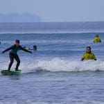 school pupil riding the waves on a surf board at the beach