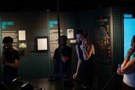 students in museum area looking at interactive activities