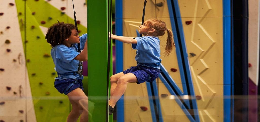 school pupils at an indoor climbing activity centre doing climbing