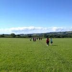 school pupils hiking along open fields