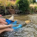 two students with science nets doing river studies