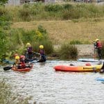 school pupils doing kayaking on a lake