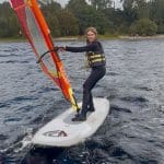 school pupil on wind surfing on a lake